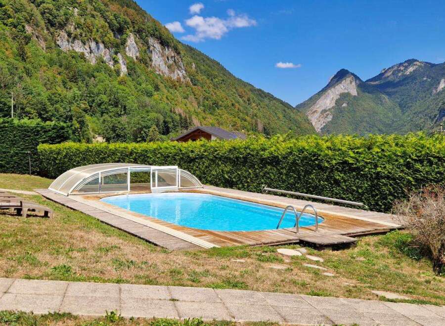 Escape to this stunning mountain retreat featuring a beautiful swimming pool with a retractable cover, perfect for year-round enjoyment.