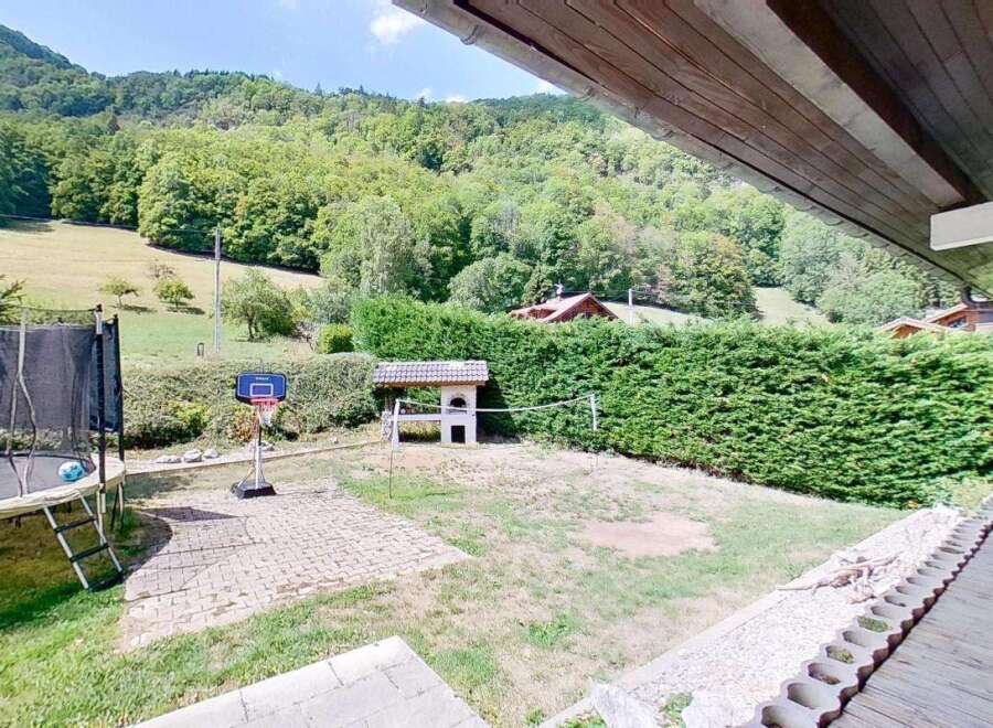 Enjoy outdoor fun in this spacious backyard featuring a trampoline and basketball hoop, perfect for active families.