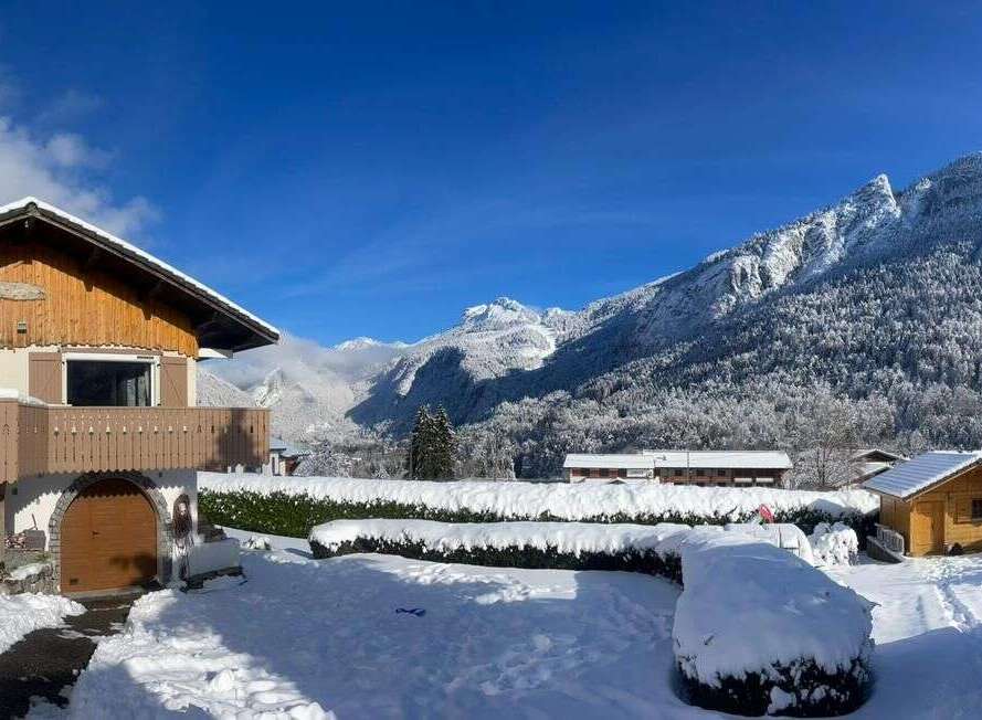 Experience the charm of a winter wonderland with this picturesque property nestled amidst snow-covered mountains.