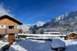 Experience the charm of a winter wonderland with this picturesque property nestled amidst snow-covered mountains.