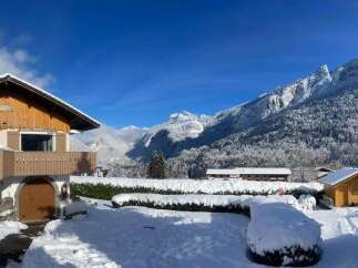 Experience the charm of a winter wonderland with this picturesque property nestled amidst snow-covered mountains.