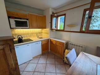 This charming kitchen features warm wooden cabinetry and a functional layout perfect for meal preparation.