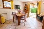 Enjoy meals with a view in this charming dining area, featuring a rustic wooden table and comfortable upholstered chairs.