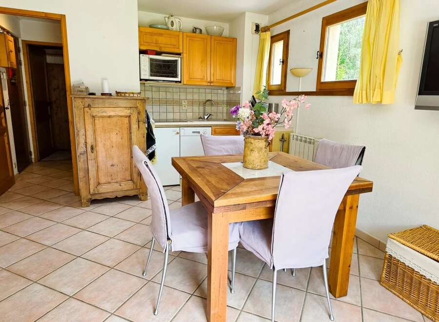 This charming dining area features a rustic wooden table surrounded by comfortable chairs, perfect for family meals.