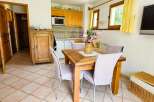 This charming dining area features a rustic wooden table surrounded by comfortable chairs, perfect for family meals.