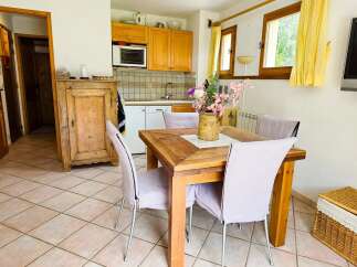 This charming dining area features a rustic wooden table surrounded by comfortable chairs, perfect for family meals.