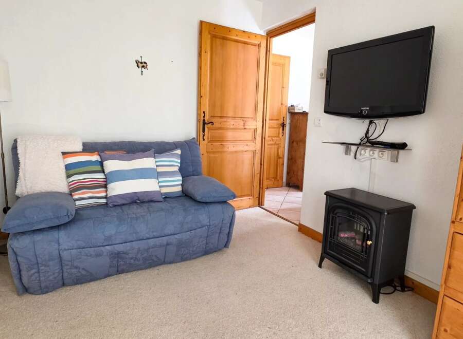 Cozy living room featuring a comfortable blue sofa adorned with striped throw pillows and a plush white blanket.