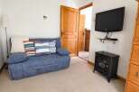 Cozy living room featuring a comfortable blue sofa adorned with striped throw pillows and a plush white blanket.