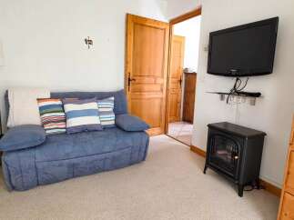 Cozy living room featuring a comfortable blue sofa adorned with striped throw pillows and a plush white blanket.