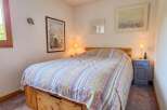 This charming bedroom features a comfortable bed adorned with a colorful, patterned comforter.