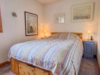 This charming bedroom features a comfortable bed adorned with a colorful, patterned comforter.