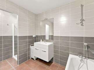 This modern bathroom features a spacious walk-in shower and a separate bathtub, perfect for relaxation.