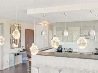 Illuminate your modern kitchen with these stunning faceted pendant lights, creating a dazzling focal point above the sleek breakfast bar.