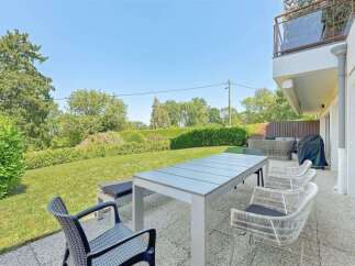 Enjoy outdoor living with this spacious patio featuring a modern dining set and comfortable seating, perfect for al fresco meals.