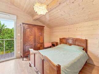 Experience rustic charm in this cozy bedroom featuring a beautiful wooden wardrobe and a comfortable bed with light blue linens.