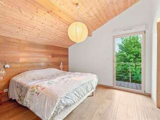 Experience cozy living in this charming bedroom featuring warm wood paneling on the walls and ceiling, creating a natural and inviting atmosphere.