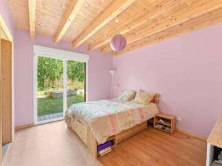 This charming bedroom features a cozy bed with a floral comforter, complemented by a wooden bed frame with built-in storage.