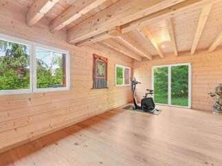 Experience tranquility in this charming wooden cabin, featuring a dedicated home gym space with an exercise bike.