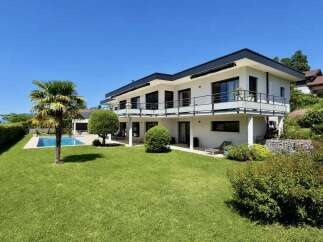 Experience luxurious modern living in this stunning white villa, featuring expansive balconies with glass railings and sleek black accents.