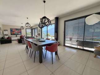 Experience modern living in this spacious open-plan dining and living area, featuring a sleek dining table with stylish chairs and a contemporary fireplace.