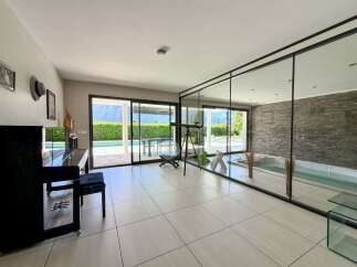 Experience luxury living in this stunning property featuring a grand piano and a private indoor spa with a stone accent wall.