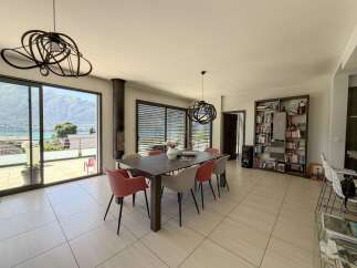 Experience modern living in this spacious dining area, featuring a sleek dark wood table surrounded by stylish upholstered chairs.