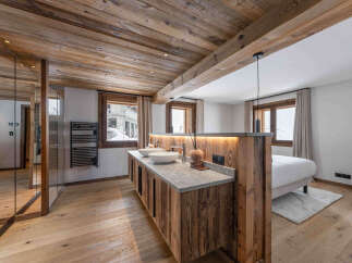 Experience luxury mountain living in this stunning bedroom featuring an open-plan en-suite bathroom.