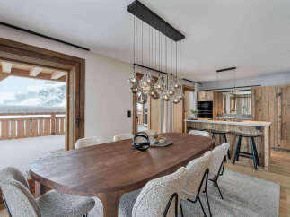 Experience luxurious mountain living in this stunning dining area, featuring a large wooden table perfect for family gatherings.
