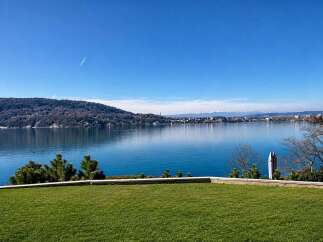 Experience breathtaking lakefront living with this stunning property offering panoramic views of the serene blue waters and distant snow-capped mountains.