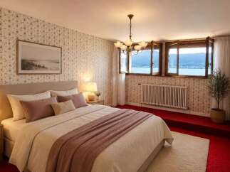 Experience breathtaking lake views from this charming bedroom, featuring a cozy bed adorned with plush pillows and a soft throw.