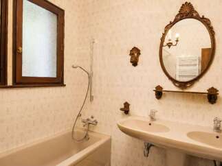 This charming bathroom features a classic bathtub and a double sink vanity, perfect for a relaxing retreat.