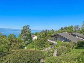 Experience breathtaking lake views from this stunning property, nestled amidst lush greenery and mature trees.