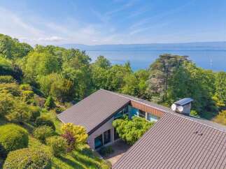 Experience breathtaking lake views from this stunning property, nestled amidst lush greenery and mature trees.