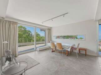 Enjoy breathtaking views from this spacious dining area, featuring a large sliding glass door that opens onto a scenic balcony.