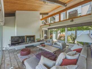Experience modern living in this stunning multi-level home featuring a spacious living area with a cozy fireplace and a large TV.