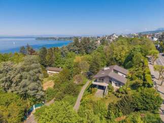 Discover this stunning modern home nestled amidst lush greenery with breathtaking lake views.