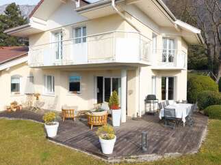 Enjoy outdoor living on this spacious wooden deck, perfect for entertaining with a dining set and a grill.