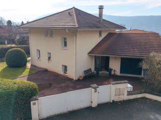 Discover this charming property featuring a well-maintained exterior with a large, manicured lawn and a striking spherical topiary.