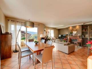 This spacious living and dining area features a large wooden dining table with comfortable chairs, perfect for family meals.