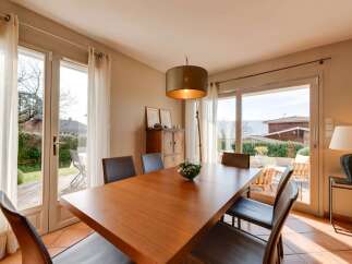 This elegant dining room features a large wooden table with comfortable seating, perfect for family gatherings.