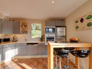 This charming kitchen features light gray cabinetry and a spacious double sink, perfect for meal preparation.