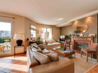Experience luxurious living in this beautifully appointed living room, featuring a plush leather sectional sofa and a cozy fireplace with ornate detailing.