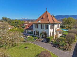 Discover this exquisite property featuring a charming villa with a distinctive red-tiled roof and elegant arched entryway.