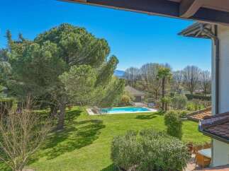 Enjoy the ultimate outdoor living experience with this stunning property featuring a sparkling swimming pool surrounded by lush green lawns and mature trees.