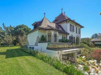 Discover this charming property featuring a picturesque facade with stone accents and a distinctive turreted roofline.