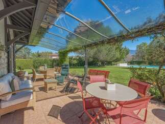 Enjoy outdoor living under a stunning glass-covered patio, perfect for al fresco dining and relaxation.