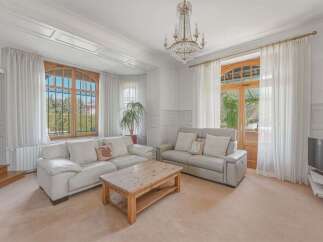 Step into this elegant living room, bathed in natural light from large windows and a stunning crystal chandelier.