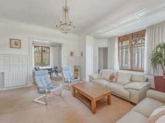 Step into this elegant living room, featuring a luxurious crystal chandelier and a large bay window that floods the space with natural light.