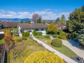 Discover this charming single-family home nestled in a serene neighborhood, boasting a well-maintained garden with vibrant yellow and red flowering bushes.