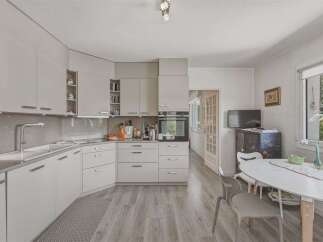 Discover this modern and functional kitchen featuring sleek white cabinetry and a convenient L-shaped countertop.